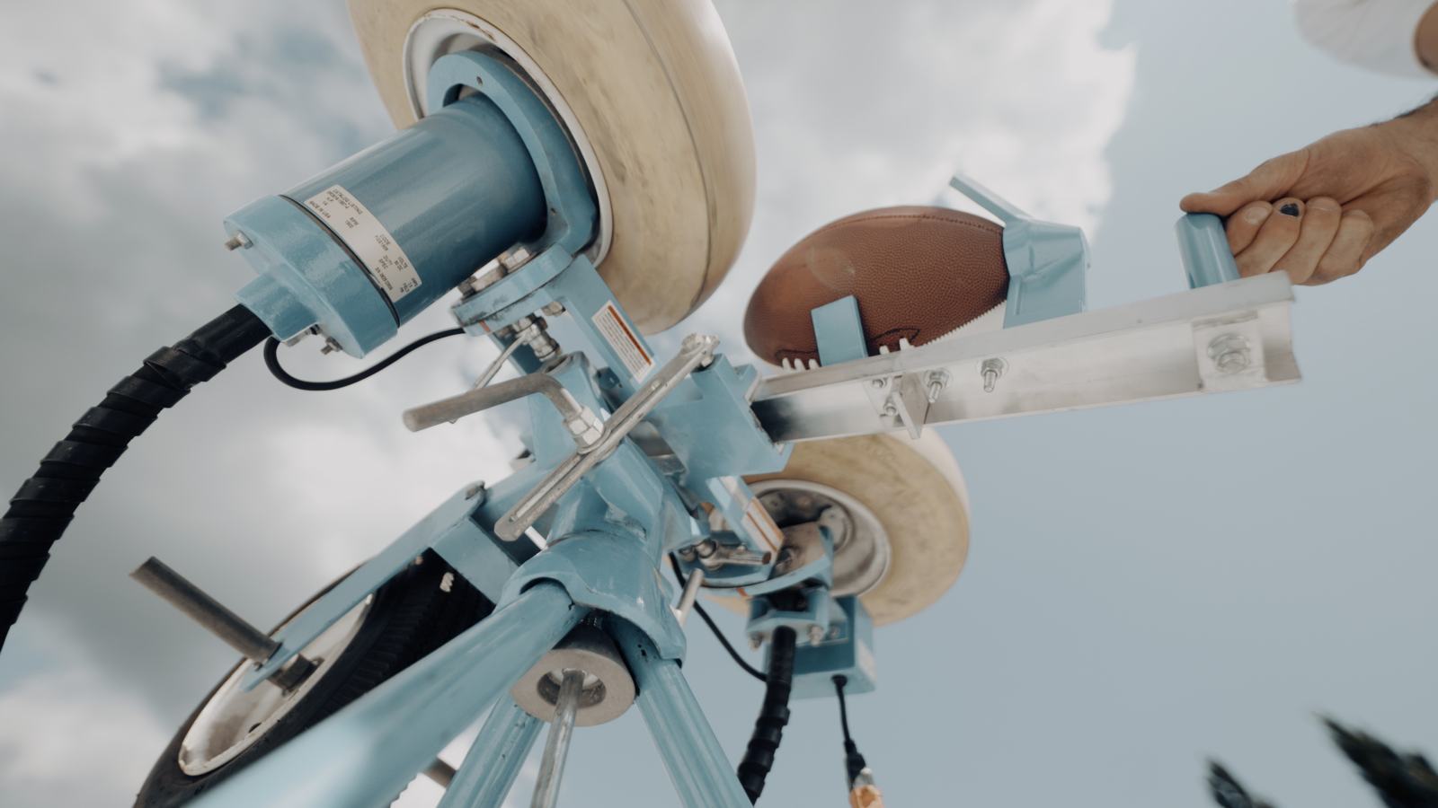 Low-angle detail of a ball launcher against the sky
