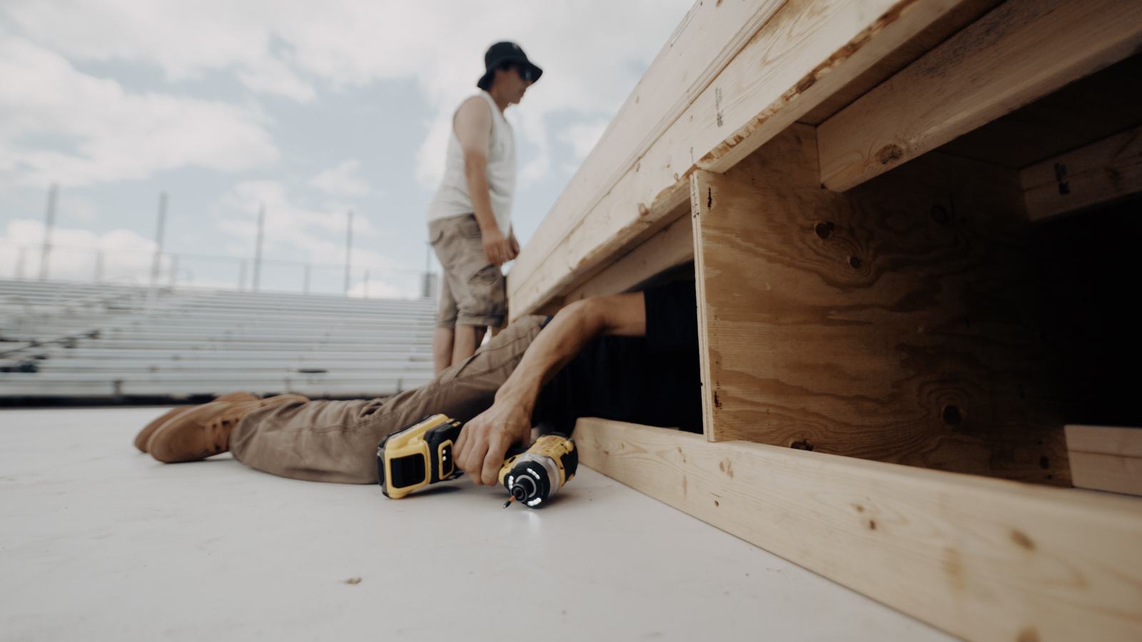 Builder lying under a ramp frame with a DEWALT driver