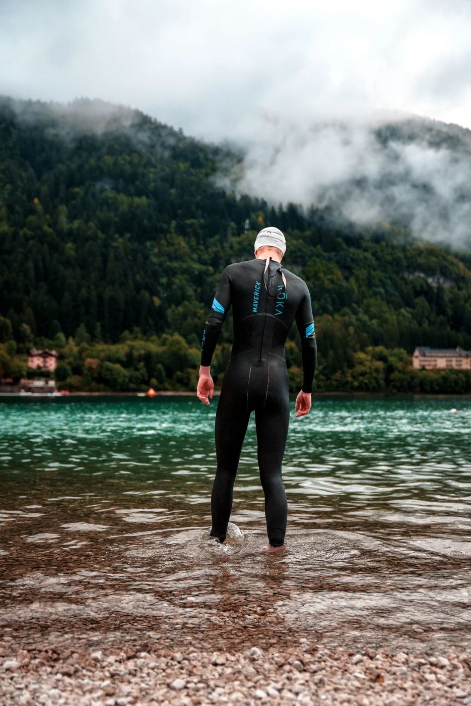 Triathlete wading into an alpine lake