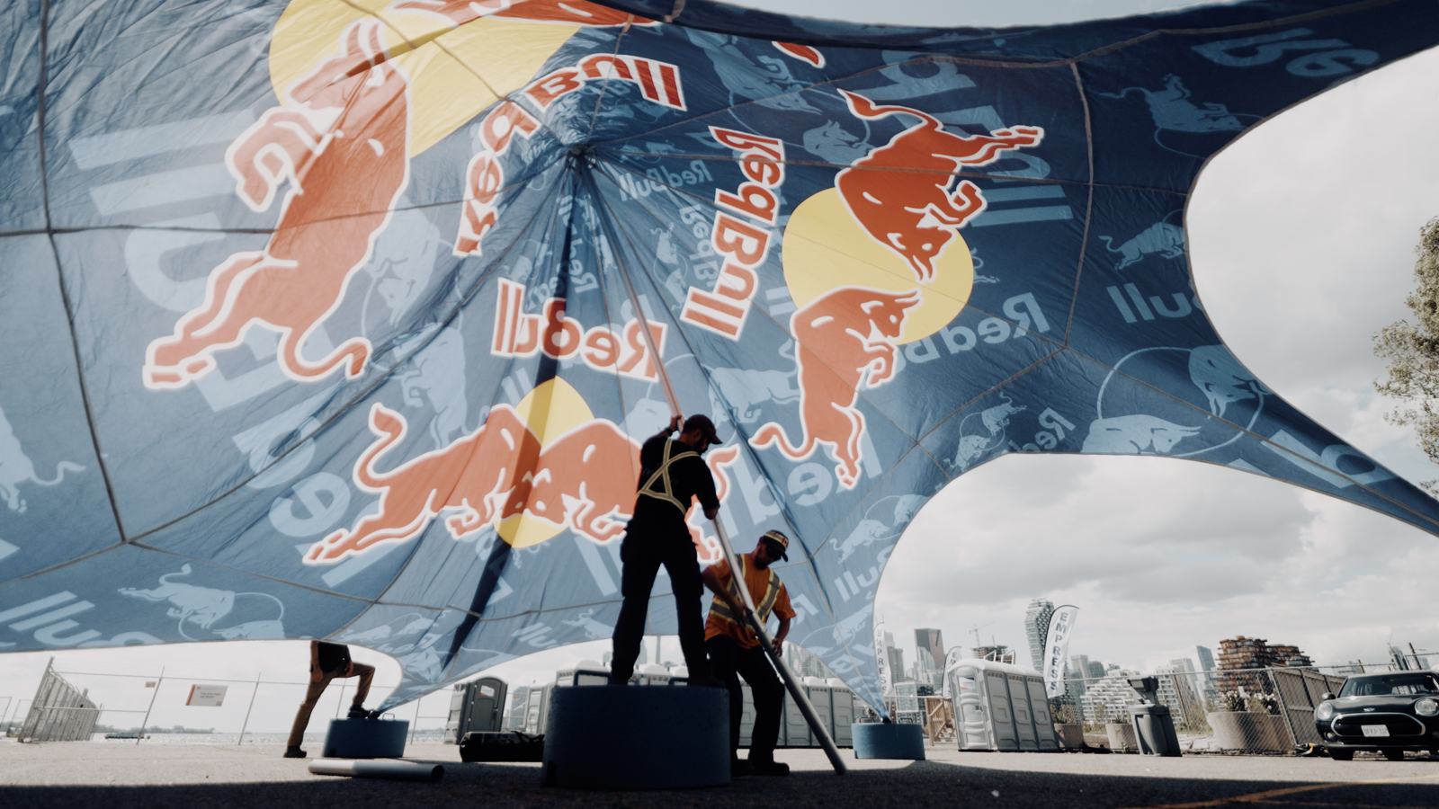 Crew raising the Red Bull canopy with the skyline behind